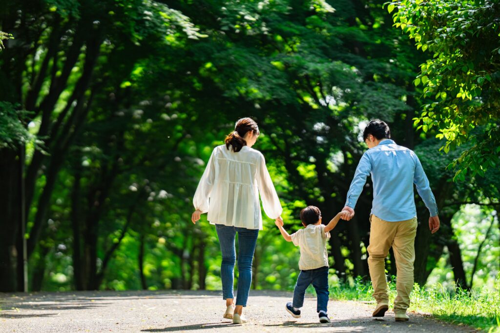 A family walking in a park with fresh greenery